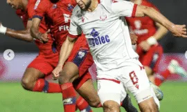 Le joueur du WAC H. Sakhi (Blanc) en lutte avec les défenseurs de l'OCS.