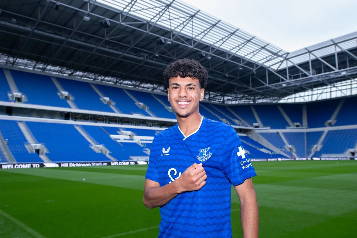 alt="Adam Aznou pose en maillot d’Everton sur la pelouse du Hill Dickinson Stadium après son transfert depuis le Bayern Munich"