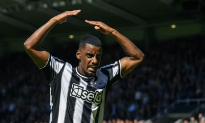 Alexander Isak célébrant un but avec Newcastle, levant les bras au-dessus de la tête devant les supporters.