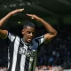 Alexander Isak célébrant un but avec Newcastle, levant les bras au-dessus de la tête devant les supporters.