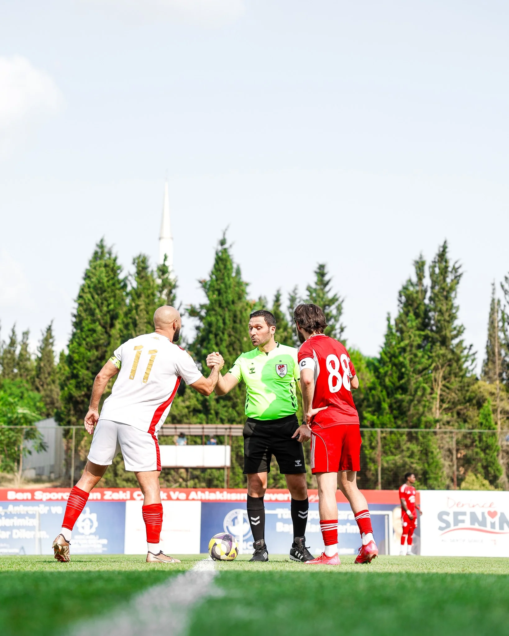 Nordin Amrabat, joueur du Wydad Casablanca, salue le capitaine de Turan Tovuz avant le coup d’envoi d’un match amical en Turquie, sous le regard de l’arbitre.