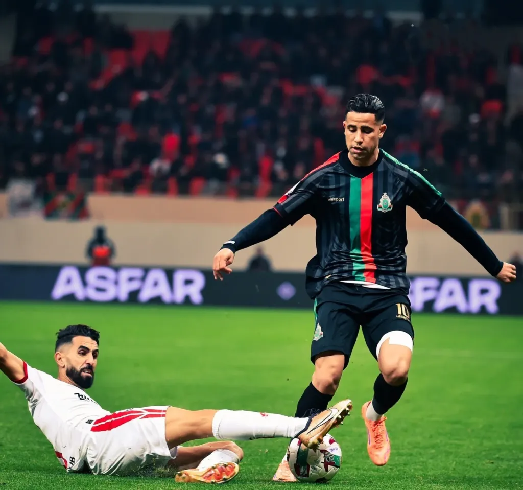 ALT= le joueur de l'AS FAR, Reda Slim, a mis à terre un défenseur du CODM lors du match ayant opposé les deux équipes à l'occasion de la 14e journée de la Botola.