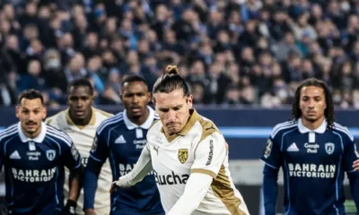 alt="Un joueur de Lens tire un penalty contre le Paris FC lors d’un match de Ligue 1"