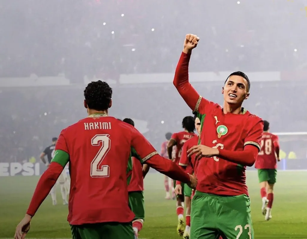 Alt= Bilal El Khannouss célébrant son but face au Paraguay avec son capitaine Achraf Hakimi passeur décisif.