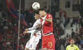 alt= duel aérien entre un joueur du WAC et un atre de l'OCS lors du quart de finale aller de la Coupe de la CAF.